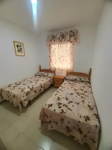 马塔拉斯卡尼亚斯bonito apartamento en caño guerrero, Matalascañas的一间卧室设有两张床和窗户。