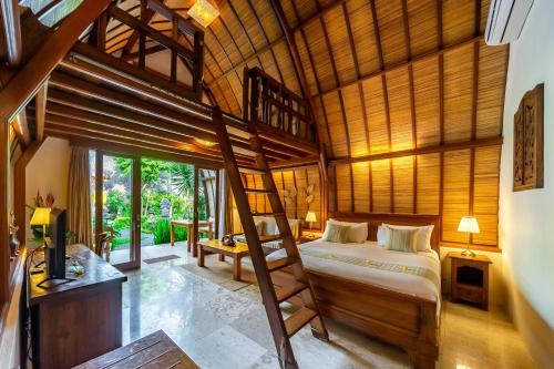 沙努尔Klumpu Bali Resort的一间带一张床的卧室,位于带木制天花板的房间内