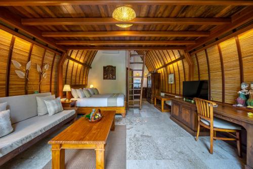 沙努尔Klumpu Bali Resort的一间配备有沙发、床和电视的客房