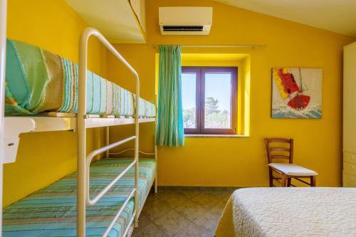 阿列恩图Casa Baia Vignola的黄色客房中一间带双层床的卧室