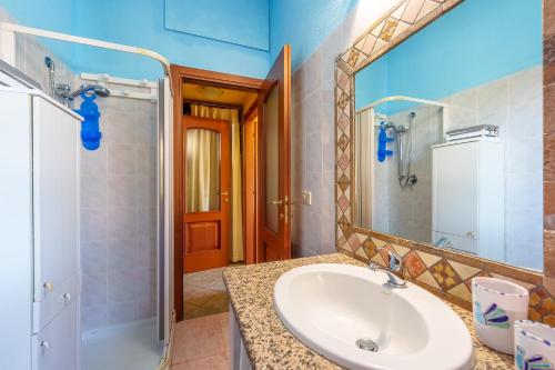 阿列恩图Casa Baia Vignola的一间带水槽、淋浴和镜子的浴室