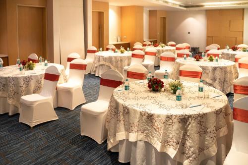 海得拉巴海得拉巴喜来登酒店的一间会议室,配有桌椅和白色的桌布