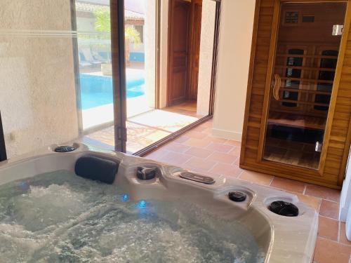 拉克罗勒布勒天井酒店的一个带按摩浴缸的浴室,带游泳池