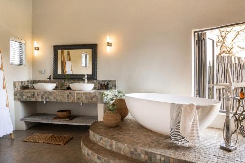 提姆巴瓦提禁猎区西姆拜瓦提河酒店的一间带大浴缸和两个盥洗盆的浴室