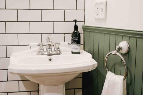 泉佐野THE BEDFORD LODGE的一间带白色水槽和一瓶葡萄酒的浴室