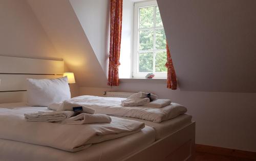 弗里克苏姆Strandperle Herrenhof的卧室设有两张床,带窗户