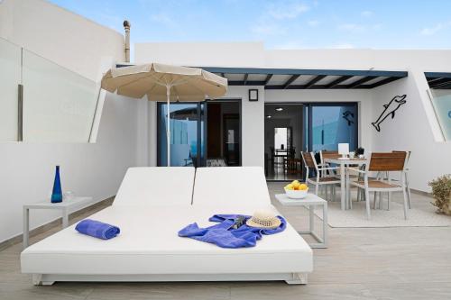 阿列塔Callao Beach 8的卧室配有白色的床和雨伞。
