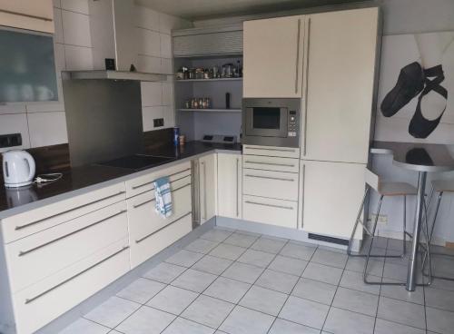 阿尔泽特河畔埃施Private Room in Esch-sur-Alzette的厨房配有白色橱柜和白色瓷砖地板。