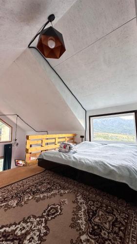 BesqaynarДом в горах Уютный дом с потрясающим видом и огромной террасой的一间卧室设有一张床和一个大窗户