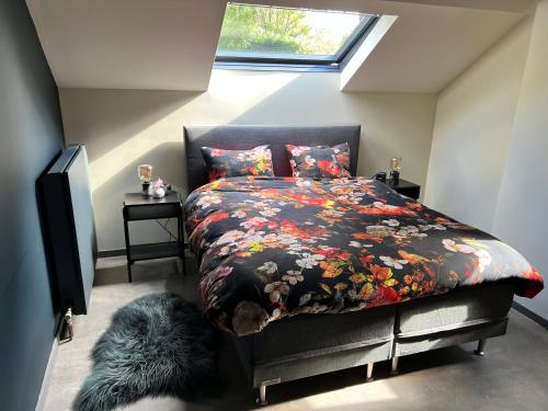 旧蒂尔瑙特Ikigai的一间卧室配有一张带花卉棉被的床