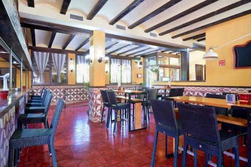 卡索拉Hotel Rural Cazorla Posada del Cordobés的一间带桌椅的餐厅和一间酒吧