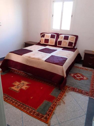El Kelaa des SrarhnaBel Appartement à El kelaa Des Srarhna的地板上带地毯的房间的一张床位