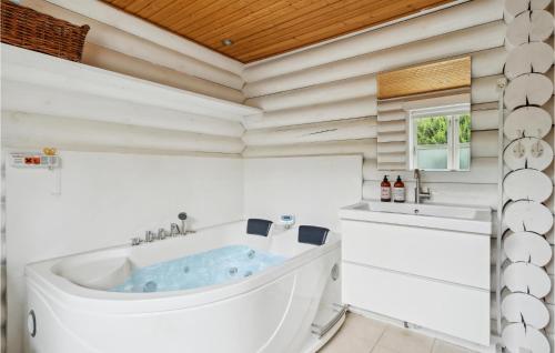 Pollerup KullegårdStunning Home In Stege With Wifi的白色的浴室设有浴缸和水槽。