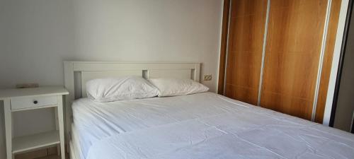 得土安Urban corner的卧室配有白色的床和木制橱柜。