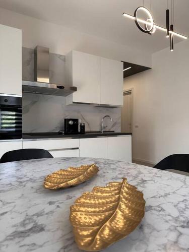 科莫Appartamento Dolce Vita - Parking & Self Check-in的厨房配有大理石桌子和两金鞋