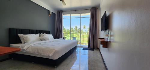 图杜Rihiveli Residence Thoddoo的一间卧室设有一张床和一个大窗户