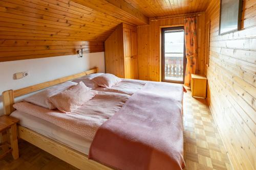博希尼Apartments Pri Urhu的木制客房的一张床位,设有窗户