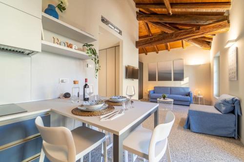 科莫Moderno Appartamento a 200 metri dal Duomo的厨房以及带桌椅的起居室。