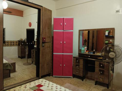 安曼Flowers apartment的更衣室配有红色橱柜和镜子