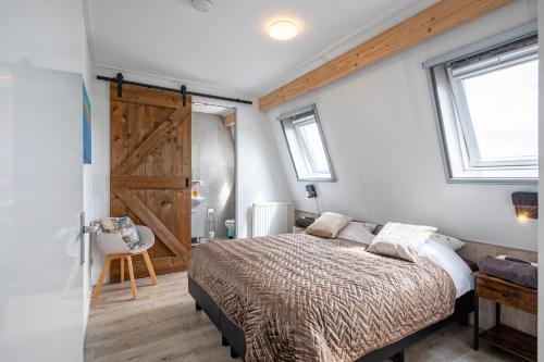 登堡Wulpenweid Bed & Parking的一间卧室配有床和滑动谷仓门。
