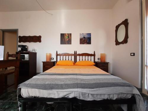 奥尔科费利诺Affittacamere San Lorenzino的一间卧室配有带橙色枕头和镜子的床