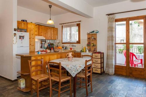 阿瑞罗波利斯LESKA APARTMENT IN ARGYROUPOLI的厨房配有桌子、椅子和桌子,厨房