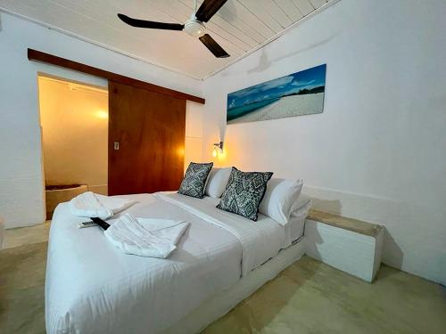 罗克斯群Posada Lagunita的卧室配有白色的床和吊扇