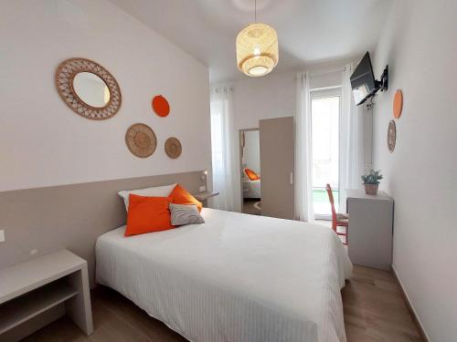 圣贝内代托-德尔特龙托Affittacamere Casa Lilibet的卧室配有带橙色枕头的大型白色床