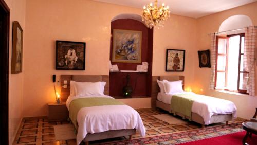 卡萨布兰卡Ryad 91的一间卧室配有两张床和吊灯。