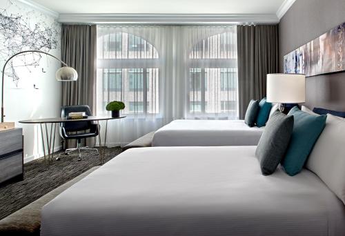 旧金山Hotel Zelos San Francisco的酒店客房配有两张床和一张书桌