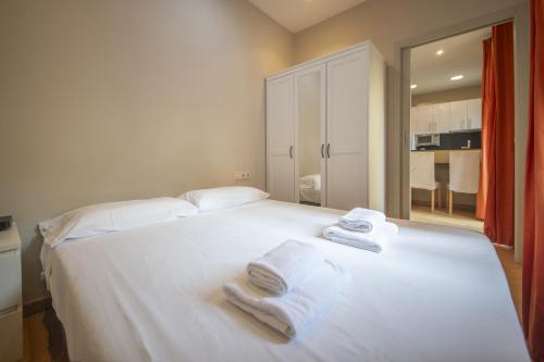 巴塞罗那Catalunya Casas 2 bed apartment in Barceloneta steps from the beach的卧室配有白色床和毛巾