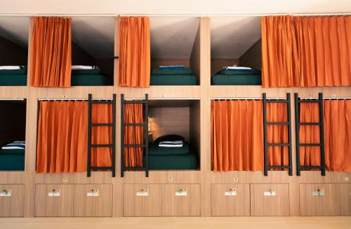 珀尼达岛The Penida Project的配有橙色窗帘和双层床的房间