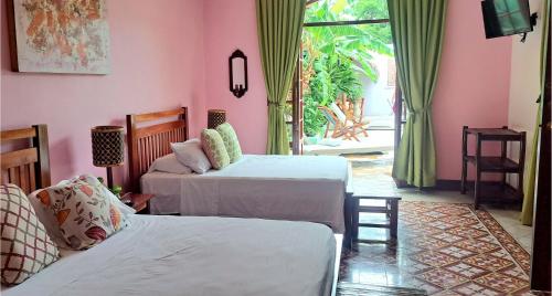 格拉纳达Hotel La Polvora的一间卧室设有两张床,并设有一个通往庭院的门。