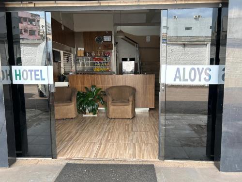 卡斯卡韦尔Aloys Hotel的一间酒店的玻璃门,里面装着两把椅子