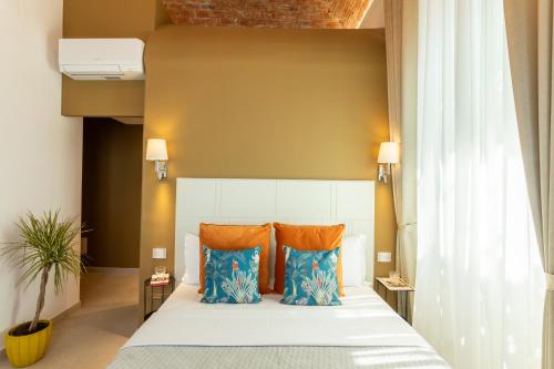 卡利亚里Magnini Rooms的一间卧室配有蓝色和橙色枕头的床