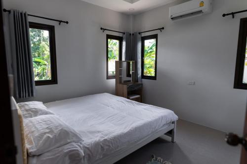 班泰Новый дом Koh Phangan的一间白色卧室,配有床和2个窗户