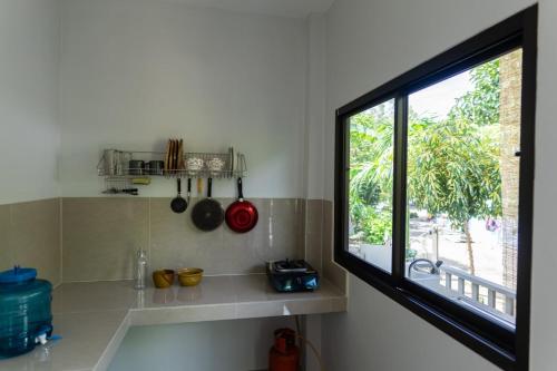 班泰Новый дом Koh Phangan的厨房设有窗户和带水槽的台面