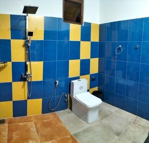 埃拉Kithaya Ella的浴室设有卫生间,铺有蓝色和黄色瓷砖。