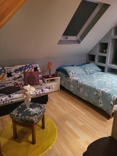 GundershoffenChambres de Fabienne的一间卧室配有两张床、一张沙发和一把椅子