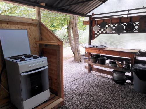 古达乌塔Отель Домик у реки Хипста的一个带炉灶和烧烤架的户外厨房