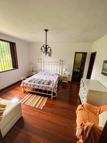 彼得罗波利斯Chale das hortensias的一间卧室配有一张床,铺有木地板
