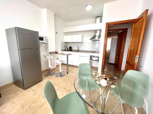 罗萨里奥港Little Home的厨房配有玻璃桌和绿色椅子