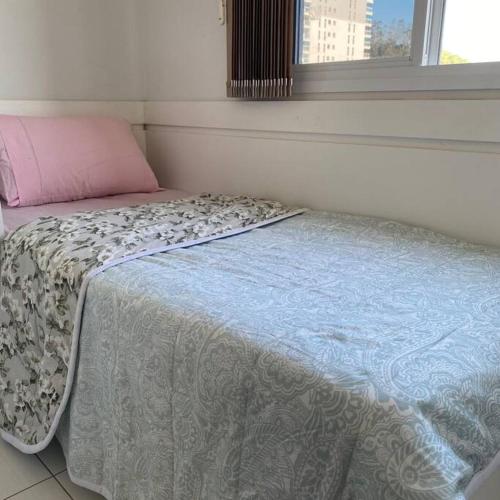 布吕斯克Quarto solteiro em brusque的卧室内的一张床铺,上面有粉红色枕头