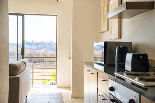 SandtonLush Studio Apartment with Back-Up Power.的厨房享有阳台的景致。