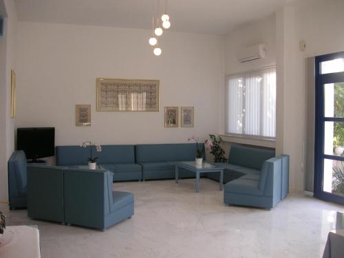 萨索斯达娜厄酒店 的客厅配有蓝色的沙发和电视