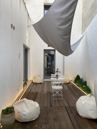 贡内萨LUVIA ROOMS SPA的铺有木地板的庭院配有桌椅