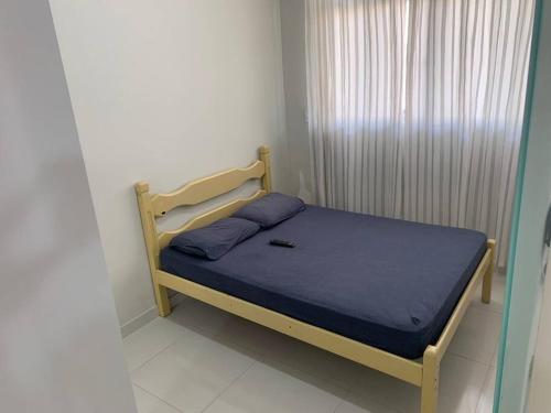 坎普斯戈伊塔卡济斯Quitinete Aconchegante Prq Pelinca的小卧室配有一张带蓝色毯子的床