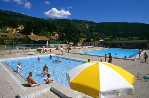 蒙布兰莱班VVF Drôme Provence的一个带黄色和白色遮阳伞的游泳池