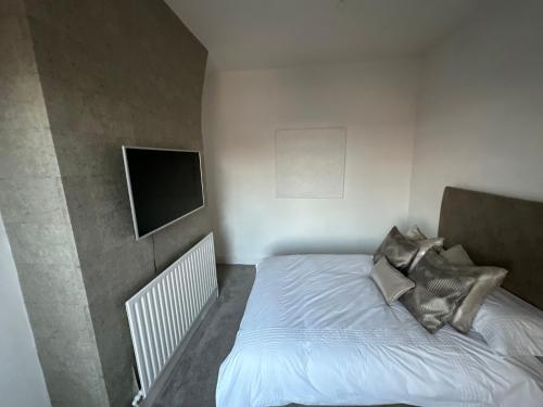 利物浦3 Bedroom House on Beatles Famous Road的一间小卧室,配有一张床和一台平面电视