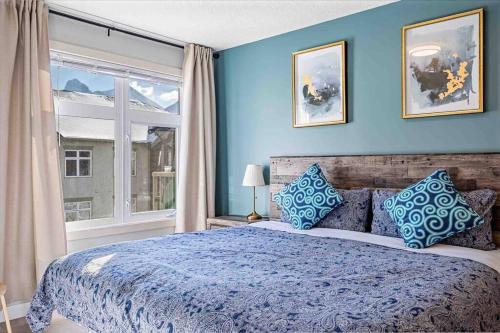 坎莫尔Lux 2BR 5BD Suite Mountain view!的蓝色的卧室设有一张大床和一个窗户